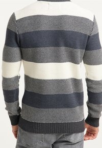 Maglione lavorato a maglia con strisce orizzontali in blu navy e bianco, realizzato in un tessuto testurizzato e traspirante, con polsini e orlo a coste.