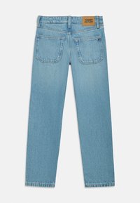 Světlé modré džíny s rovný střih, dvě zadní kapsy a kožený štítek v barvě tan na pase s nápisem "Tommy Hilfiger."