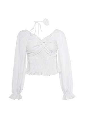 Biały crop top z długim rękawem, marszczonym biustem, marszczonym pasem, falbankami na mankietach i cienkim wiązaniem na szyi z małym kwiatkiem z materiału.