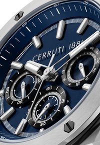 Cerruti 1881 hronogrāfiskā pulksteņa ar tumši zilu ciparnīcu, sudraba akcentiem, trim sub-dialiem un nerūsējošā tērauda korpusu. Iezīmes teksturēti raksti.