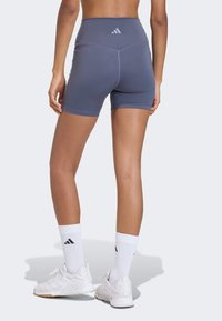 High-waisted, grey athletic shorts with a smooth texture, featuring a contrasting waistband and logo detail at the back.