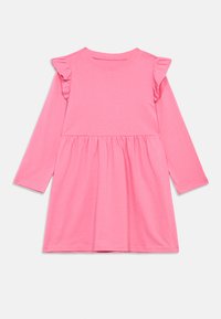 Ρόζ μακρυμάνικο φόρεμα από μαλακό ύφασμα, με ραμμένα ώμους και συγκεντρωμένη μέση, που έχει χαλαρή εφαρμογή και λεία υφή.