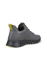 Szare buty sportowe z teksturowaną skórzaną cholewką, żółtymi akcentami i elastyczną czarną gumową podeszwą. Posiadają wzorzysty tylny uchwyt.