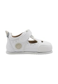 Zapato infantil de cuero blanco con detalles troquelados, correa de Velcro, punta redondeada, suela texturizada y acento de logo circular en el lateral.