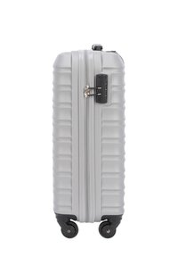 Silver hardshell suitcase with ribbed texture, double zippers, integrated lock, and four black spinner wheels for easy mobility.