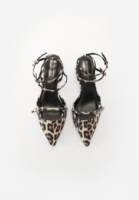 Pumpe s uzanim vrhom u leopard uzorku s crnim trakama, s tankim dizajnom oko gležnja i malim zlatnim kopčama. Veganski materijal, glatka tekstura.