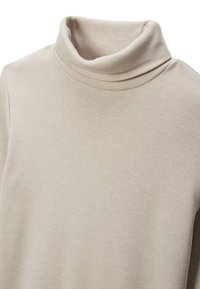 Pull à col roulé beige en texture côtelée, avec un col haut et un tissu doux. Aucune motif visible ou détail en matériel.