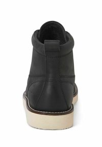 Botines de cuero negro hasta el tobillo con puntera redondeada, forro suave, costuras sutiles y suela de goma beige. Diseño minimalista con una lengüeta trasera.