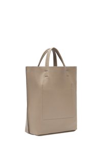 Beige leren tote bag met verticale stiksels, vlakke structuur en twee handvatten aan de bovenkant voor gemakkelijke draagbaarheid. Gladde textuurafwerking.