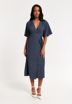 Navy blue wrap dress with short flutter sleeves, featuring a white paisley pattern and a side slit, made from a lightweight fabric.