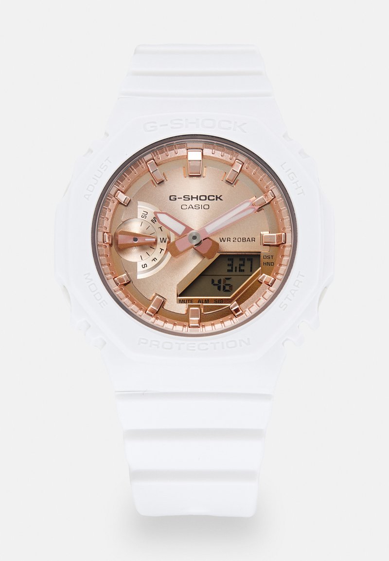 Montre G-SHOCK de Casio avec un bracelet en résine blanche, un cadran rose doré avec un affichage analogique-numérique, et une résistance à l'eau allant jusqu'à 200 mètres.