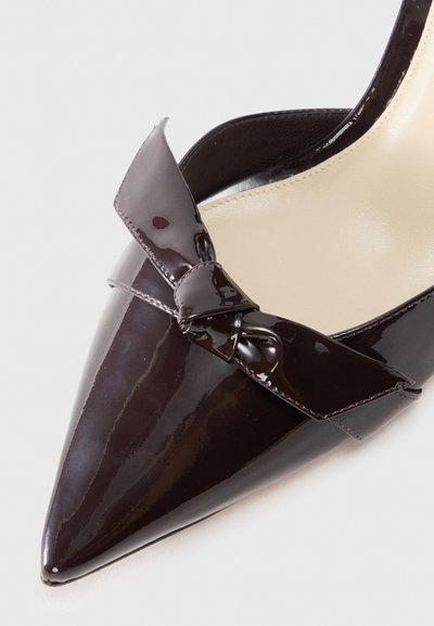 Pointed-toe high-heel shoe in dark burgundy patent leather with a decorative bow accent. Smooth texture and sleek design.