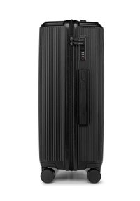 Black hard-shell suitcase with vertical ribbed texture, dual zipper closure, an integrated combination lock, and four smooth-rolling wheels.