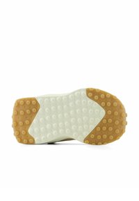 Sole of a shoe with white midsection and tan heel and toe areas, featuring circular grip patterns.