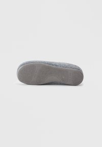 Sola de pantufa cinza em feltro com um fundo de borracha texturizada, apresentando um design elevado para aderência e a frase "FEITO EM ESPANHA" impressa.
