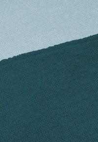 Texturierter Badematte in Dunkelblau und Hellblau; rechteckige Form mit einem weichen, gewebten Stoff. Verfügt über eine plüschige, saugfähige Oberfläche.