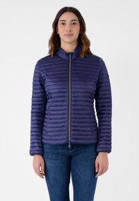 Giacca imbottita blu navy con zip frontale, texture a coste e colletto alto. Presenta un design aderente con polsini elasticizzati.