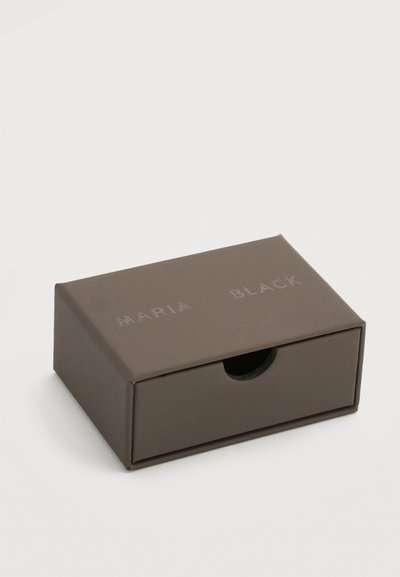 Μικρό ορθογώνιο γκρι κουτί συρταριού με στρογγυλεμένη λαβή κοπής και την ανάγλυφη επιγραφή "MARIA BLACK" στο κέντρο της κορυφής.