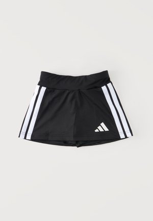 Čierna športová sukňošortka s bielymi bočnými pruhmi a logom Adidas v spodnej časti vpredu, zobrazená na jednoduchom svetlom pozadí.