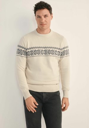 Sweter dziany w kolorze kremowym z niebieskim geometrycznym wzorem na piersi, z okrągłym dekoltem oraz ściągaczami przy mankietach i na dolnym końcu.