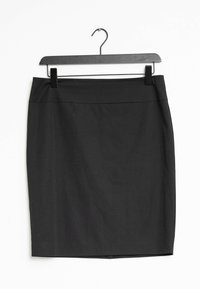 Svart pennkjol med en slät textur, med en figurnära design och utan synliga mönster, hängande på en svart plastgalge.