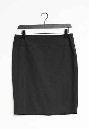 Gonna nera a matita con una texture liscia, caratterizzata da un design aderente e senza motivi visibili, appesa a un gancio di plastica nera.