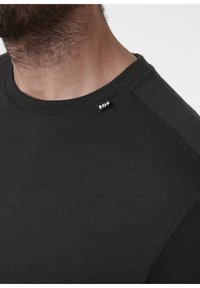 Zwarte katoenen blouse met lange mouwen en een ronde halslijn, voorzien van een klein logolabel op de linkerschouder en platte naadtoeslag.