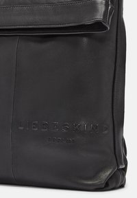 Borsa in pelle nera con una finitura testurizzata. Logo impresso "LIEBESKIND BERLIN" in evidenza. Caratterizzata da una patta pieghevole e chiusura con zip.