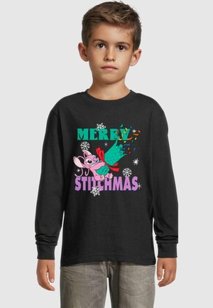 Mustaga pikkade varrukatega T-särk, millel on värviline tekst "MERRY STITCHMAS" ja joonistatud tegelane pidulikus poosis, koos lumehelves grafikaga.