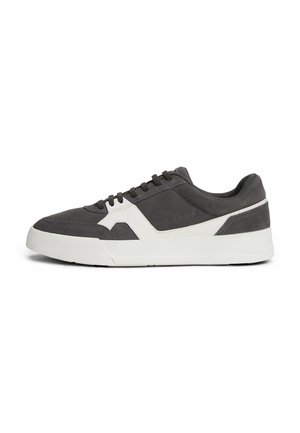 Zapatilla de ante gris con suela de goma blanca, que presenta un diseño moderno, cordones planos y un panel de acento en el costado.