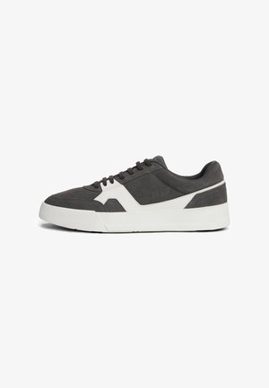 Grijze suède sneaker met een witte rubberen zool, voorzien van een modern ontwerp, platte veters en een accentpaneel aan de zijkant.
