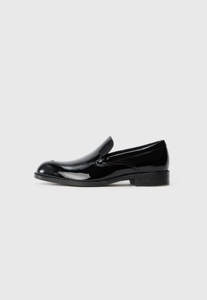 Mustad mustaläikivad nahast loafers, ümarate varvastega, libiseva disainiga, diskreetsete tikanditega ja madala kontsaga. Vastupidav kummist välistald.