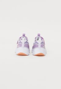 Lila Sportschuhe aus Mesh-Material, mit weißen Akzenten, einer gepolsterten Sohle und einer strukturierten Gummisohle mit einem orangenen Farbton.