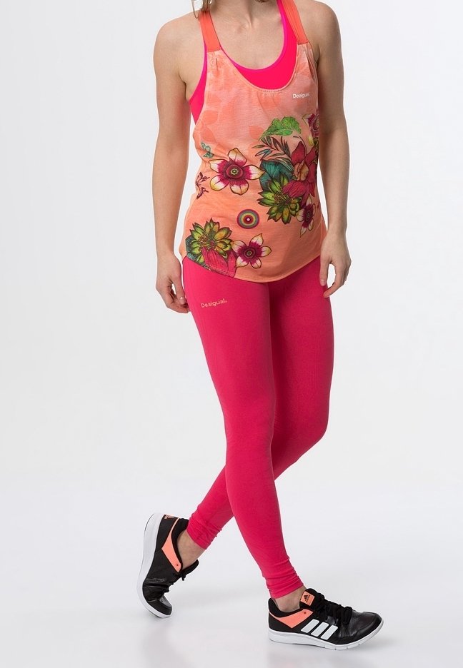 Sportowy strój składający się z pomarańczowego, bezrękawnika z kwiatowym wzorem oraz fuksjowych legginsów, uzupełniony czarnymi trampkami z różowymi akcentami.