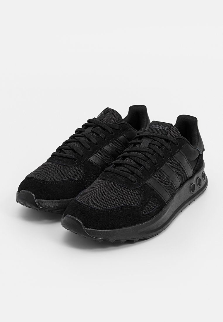 Sneaker sportive nere realizzate con una combinazione di materiali in rete e camoscio. Il design include tre strisce nere e dettagli testurizzati sulla suola.