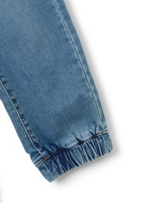 Pantalón de mezclilla azul con un dobladillo fruncido, que presenta detalles de costura a lo largo del lado y una textura suave en toda su superficie.