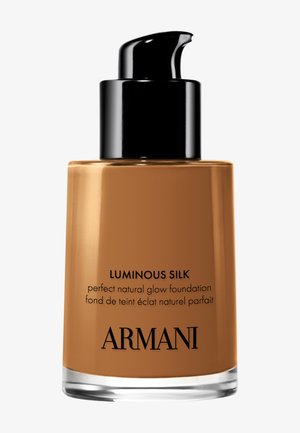 Flacon de fond de teint liquide en nuance marron moyen avec pompe noire, étiqueté « Luminous Silk perfect natural glow foundation » par Armani.