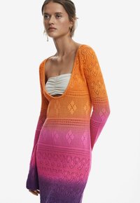 Abito di maglia con scollo a barca profondo, che sfuma da arancione a rosa a viola, caratterizzato da intricate fantasie a diamante e maniche lunghe.
