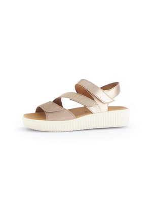 Beige sandal with crisscross straps in matte and textured materials, featuring a white rubber sole and a smooth footbed. Casual design.