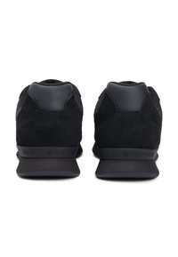 Μαύρα αθλητικά παπούτσια με συνδυασμό υλικών σουέτ και δίχτυ, κομψό σχέ διο, στρογγυλεμένη φτέρνα και ανάγλυφη σήμανση στο πίσω μέρος.