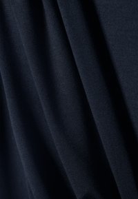 Tela azul marino con una textura suave y lisa, que presenta pliegues sutiles y una apariencia ligera, ideal para aplicaciones en ropa o cortinas.