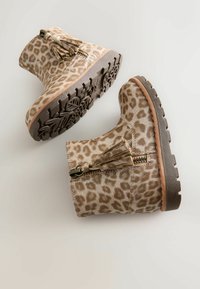 Stivaletti alla caviglia in stampa leopardata beige e marrone, con zip laterale, dettaglio frangi e suola in gomma testurizzata per una migliore aderenza.