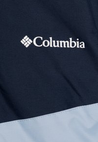 Mornarsko moder material z teksturirano površino vsebuje svetlo modro sekcijo na dnu in belo Columbia logo.