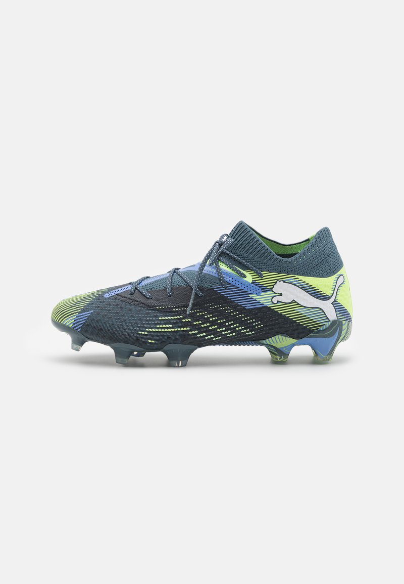 Scarpino da calcio con tomaia in tessuto a motivo blu e verde, colletto simile a una calza e tacchetti in plastica modellata per la trazione. Logo Puma ben visibile.