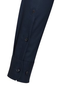 Donkerblauwe overhemdmouw met een hexagonaal manchet, twee zwarte knopen en een rozenborduursel op het manchetgedeelte.