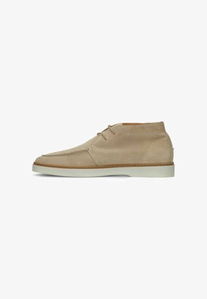 Beige suède enkellaars veterlaars met moc-toe ontwerp en witte platte rubberen zool.