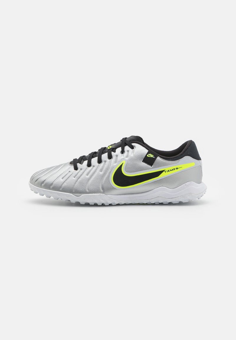 Nike Tiempo soccer shoes feature a silver synthetic upper with black laces, a vibrant yellow accent, and a textured sole for traction.