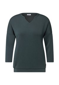 Sudadera de manga larga en verde azulado oscuro con escote en V, textura suave, ajuste relajado y un dobladillo ligeramente más largo en la parte trasera. Incluye una pequeña etiqueta de la marca en el lado.