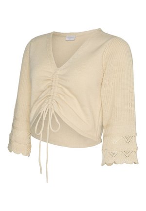 Kremowy, dziergany krótki sweter z marszczonym wiązaniem z przodu, rękawami typu dzwonek o długości 3/4 oraz koronkowymi mankietami z falbanką.