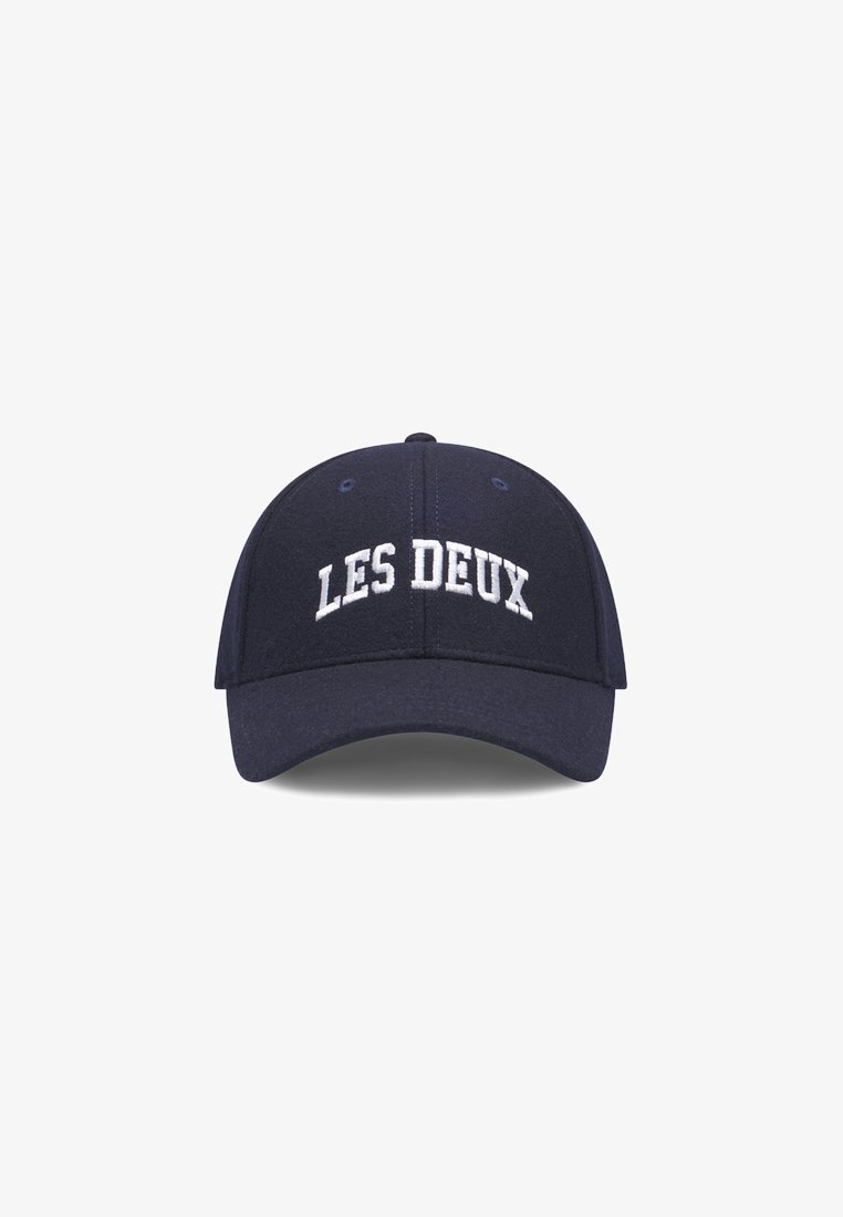 Navy blue cap made of fabric, features white embroidered text "LES DEUX" on the front, structured crown, and curved brim.